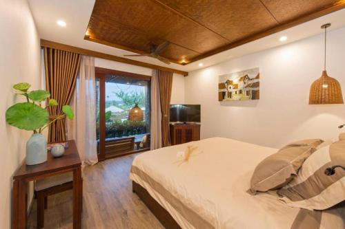 ein Schlafzimmer mit großem Bett und Fenster in der Unterkunft Hoi An Eco Lodge & Spa in Hoi An