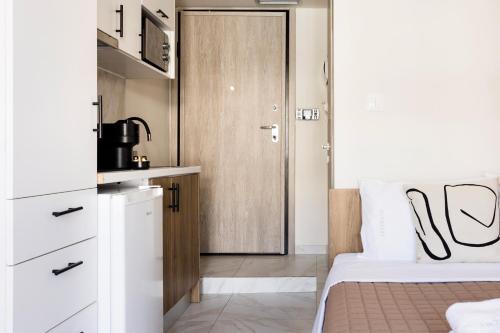 a bedroom with a door leading to a kitchen at AEONS - Hotelia Hospitality Group in Thessaloniki