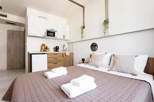 a bedroom with a large bed with two white towels at AEONS - Hotelia Hospitality Group in Thessaloniki