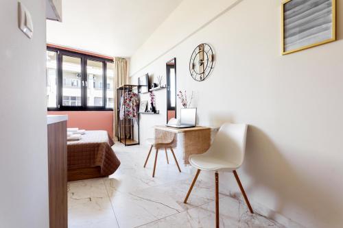 a white living room with a couch and a chair at AEONS - Hotelia Hospitality Group in Thessaloniki