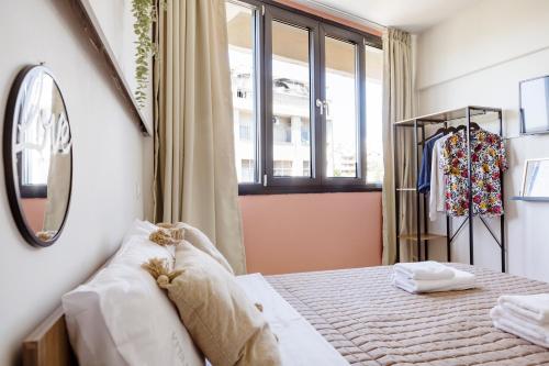 a bedroom with a bed and a window at AEONS - Hotelia Hospitality Group in Thessaloniki