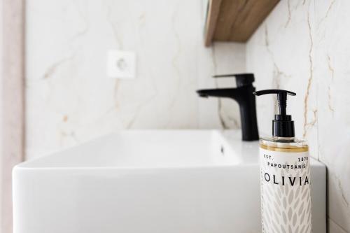 a bottle of soap sitting next to a bathroom sink at AEONS - Hotelia Hospitality Group in Thessaloniki
