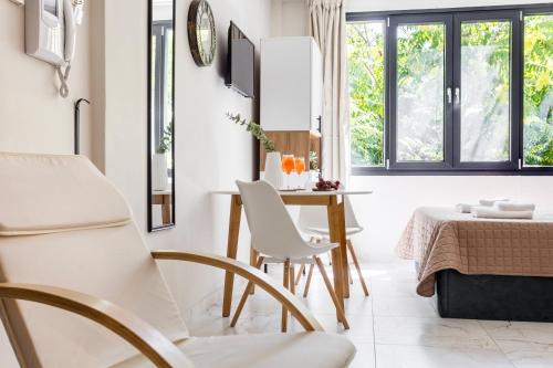 a dining room with white chairs and a table at AEONS - Hotelia Hospitality Group in Thessaloniki