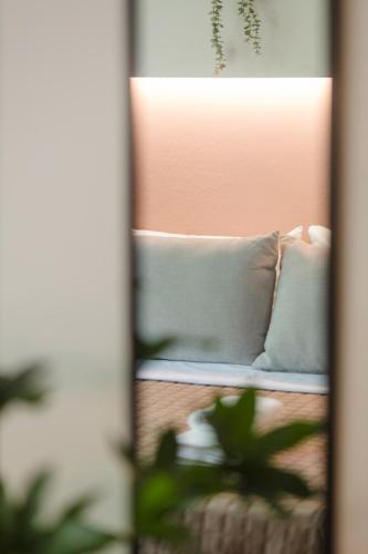 a reflection of a couch with pillows in a mirror at AEONS - Hotelia Hospitality Group in Thessaloniki