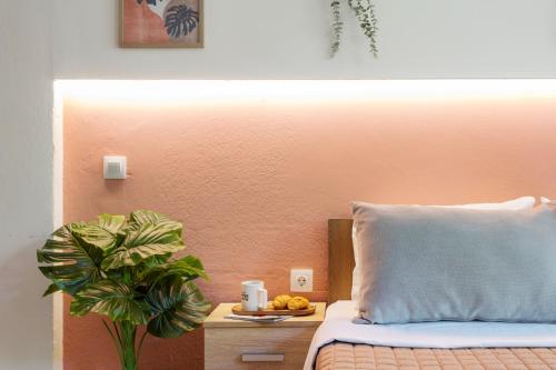a bed with a pillow and a table with a plant at AEONS - Hotelia Hospitality Group in Thessaloniki