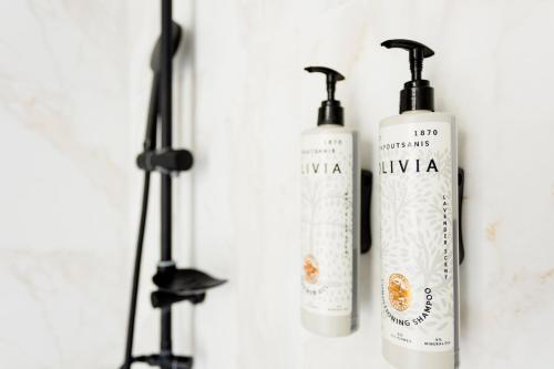 a group of three shampoo bottles on a wall at AEONS - Hotelia Hospitality Group in Thessaloniki