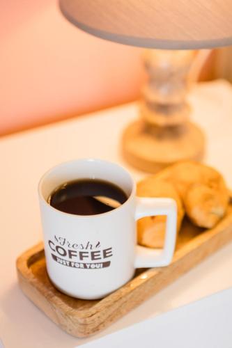 a cup of coffee and a donut on a tray at AEONS - Hotelia Hospitality Group in Thessaloniki