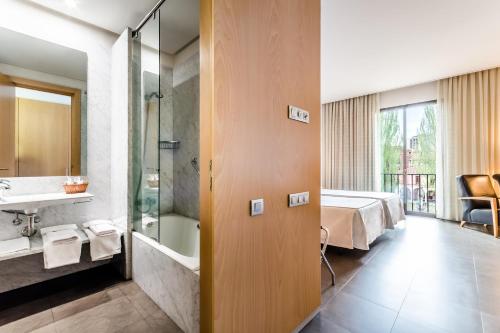a hotel room with a bed and a bathroom at Hospedería Monástica Pax in León