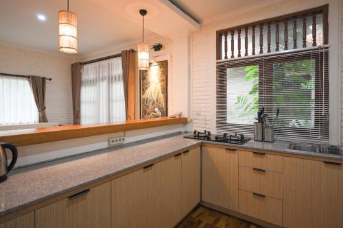 a kitchen with wooden cabinets and a sink and a window at The Taman Ayu in Seminyak