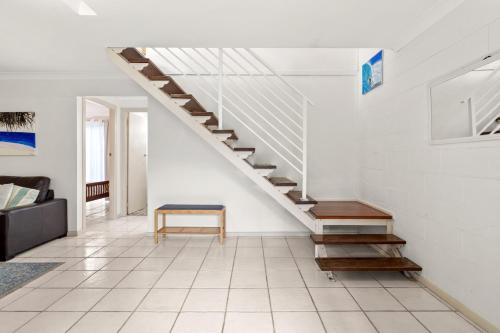 a staircase in a living room with a bench at At the Beach - Lennox Head in Lennox Head