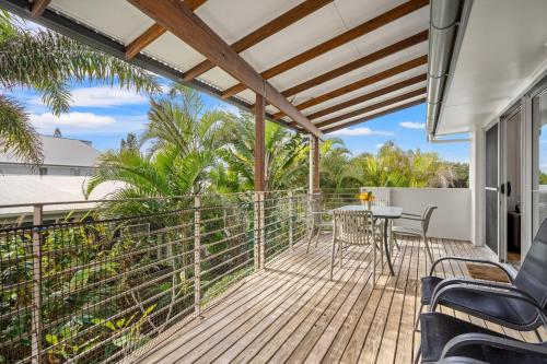 a patio with a table and chairs on a deck at At the Beach - Lennox Head in Lennox Head