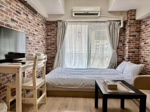 a bedroom with a bed and a brick wall at La Foret Fujimi in Hiroshima