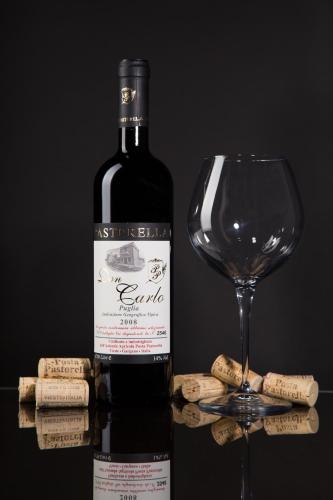 a bottle of wine next to a wine glass at Agriturismo Posta Pastorella in Vieste
