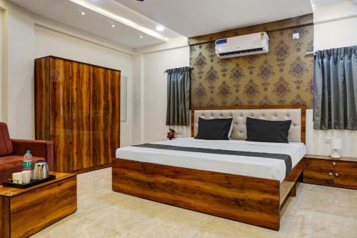 a bedroom with a large bed and a couch at Super Hotel O KP Pride in Dehu