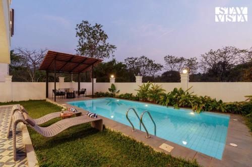 a swimming pool in the backyard of a house at StayVista at Casa Ti Amo with WiFi, AC, Pool, BBQ in Siolim
