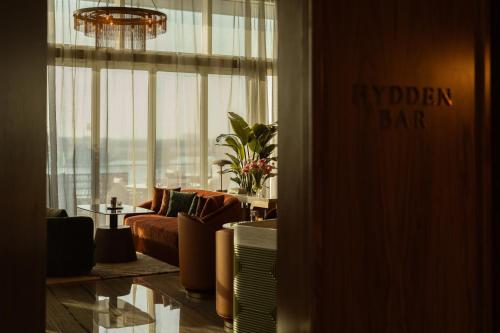 a living room with a couch and a large window at Rosewood Abu Dhabi in Abu Dhabi