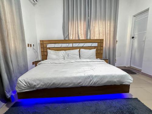 ポートハーコートにあるDee OS' Hotelのベッドルーム1室(青い照明付きの大型ベッド1台付)