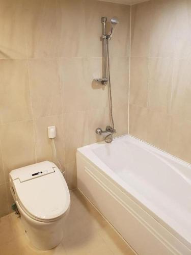 a bathroom with a toilet and a bath tub at Mstay Hotel in Seogwipo