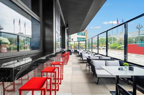 a row of tables and red chairs in a restaurant at Novotel Kunming City Center in Kunming