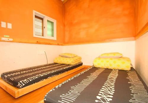 a room with two beds in a small room at Dorandoran Guesthouse in Gyeongju