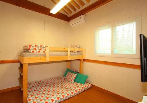 a room with two bunk beds and a window at Dorandoran Guesthouse in Gyeongju