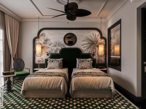 a bedroom with two beds and a ceiling fan at L'Heritage Riverside Hoi An in Hoi An