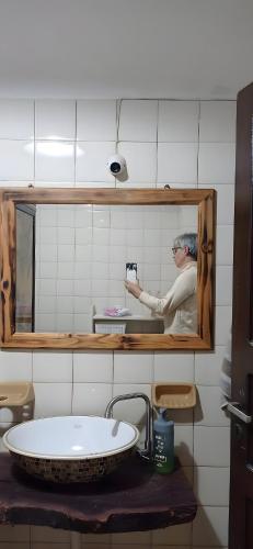 a man taking a picture of a mirror in a bathroom at Los Lapachos. La naturaleza es acá 