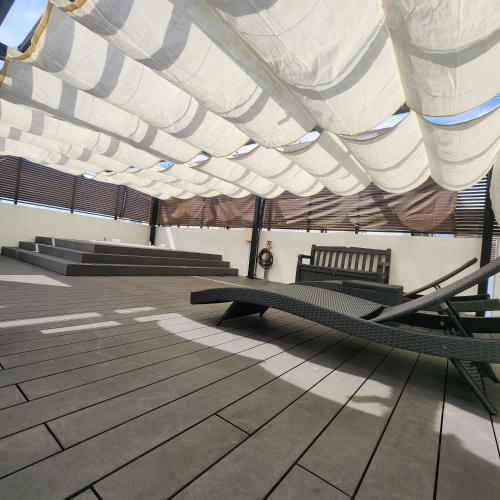 a room with a bench under a roof at 3ベッド3バス ヴィラアパラギ宮古島 in Miyako Island