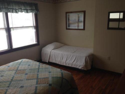 a small bedroom with two beds and a window at Echo Valley Cottages in Coolbaugh