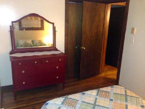 a bedroom with a dresser with a mirror on it at Echo Valley Cottages in Coolbaugh