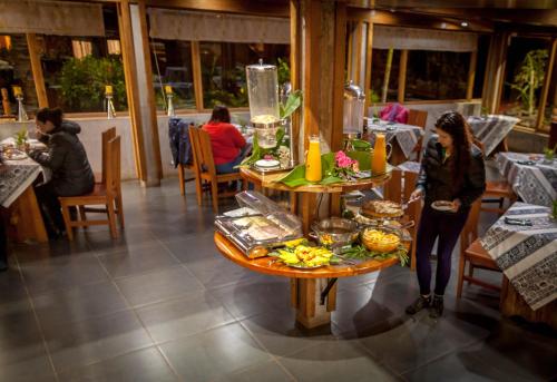 a woman standing in front of a table in a restaurant at Hotel Vai Moana in Hanga Roa