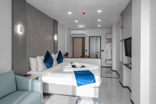a bedroom with a large white bed with blue pillows at iCom Blue Seaview in Maafushi
