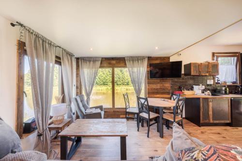 a living room with a table and chairs and a kitchen at Domek w drzewach Ostoja in Krzesimów