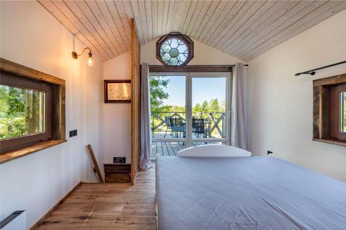 a bedroom with a large bed and a window at Domek w drzewach Ostoja in Krzesimów