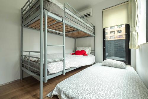 a bedroom with two bunk beds and a window at Pencil House - 10 mins walk to Shinjuku in Tokyo
