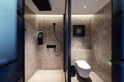 a bathroom with a shower and a toilet in it at Novotel Kunming City Center in Kunming