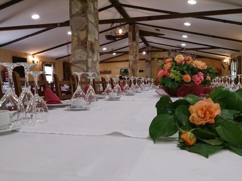 una mesa larga con vasos y flores. en Valdolázaro, en Los Navalucillos