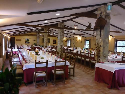 a dining room with white tables and chairs at Valdolázaro in Los Navalucillos