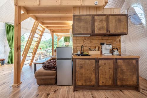 a kitchen with a refrigerator and a counter at Namiot glampingowy Forest in Krzesimów