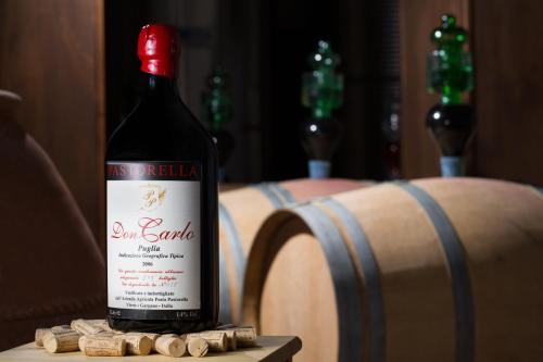a bottle of wine sitting on a table next to a barrel at Agriturismo Posta Pastorella in Vieste