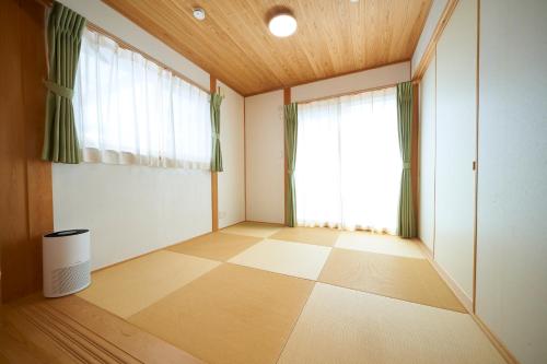 a room with a large window and a checkered floor at 貸切 KIX 25min Family-Friendly Hinoki House Free P in Kishiwada