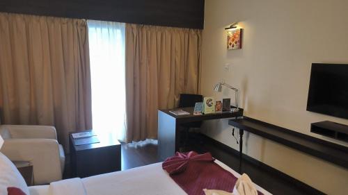 a hotel room with a bed and a television at THE WOODROSE in Bengaluru