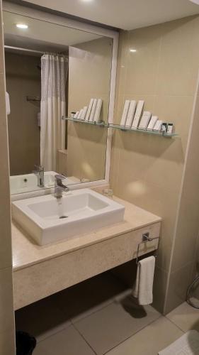 a bathroom with a sink and a mirror at THE WOODROSE in Bengaluru