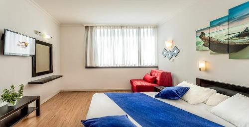 Ένα ή περισσότερα κρεβάτια σε δωμάτιο στο Inbar Hotel