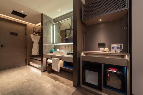 a bathroom with a sink and a mirror at Novotel Kunming City Center in Kunming