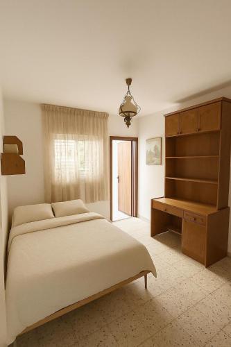 a bedroom with a large bed and a dresser at Дом для гостей in Rishon LeẔiyyon