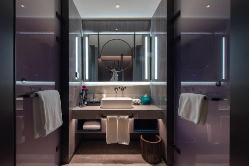 a bathroom with a sink and a mirror at Novotel Kunming City Center in Kunming