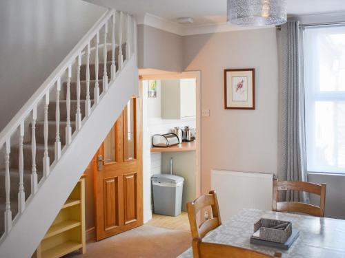 a living room with a staircase and a table at No 12 Cottage in Mold