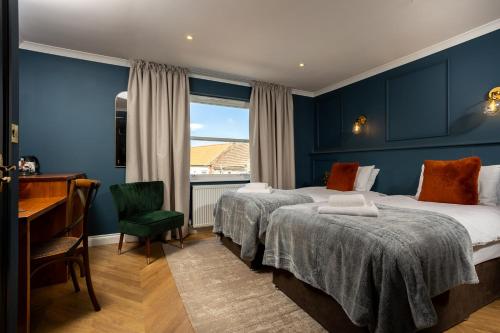 a hotel room with two beds and a desk and a window at Rob Roy - Self Check-In Boutique Accommodation in Berwick-Upon-Tweed