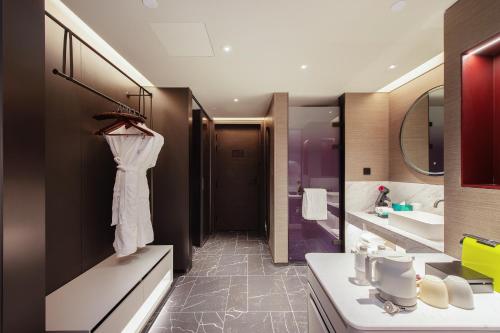 a bathroom with a white robe hanging on a wall at Novotel Kunming City Center in Kunming